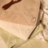La cape de bain bébé Soft Matcha en éponge 100 % coton enveloppe bébé de douceur après le bain grâce à sa matière absorbante, sa capuche à petites oreilles et son format généreux. Cape de bain bébé en éponge Soft Matcha : une sortie de bain 100 % coton douce, absorbante et confortable avec capuche pour garder bébé bien au chaud.
