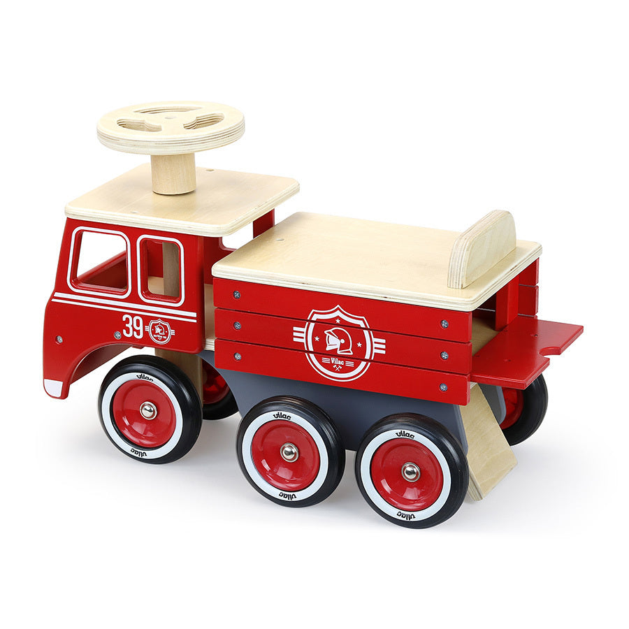 Porteur camion de pompier en bois dès 18 mois. Stable, 6 roues silencieuses et coffre de rangement intégré.