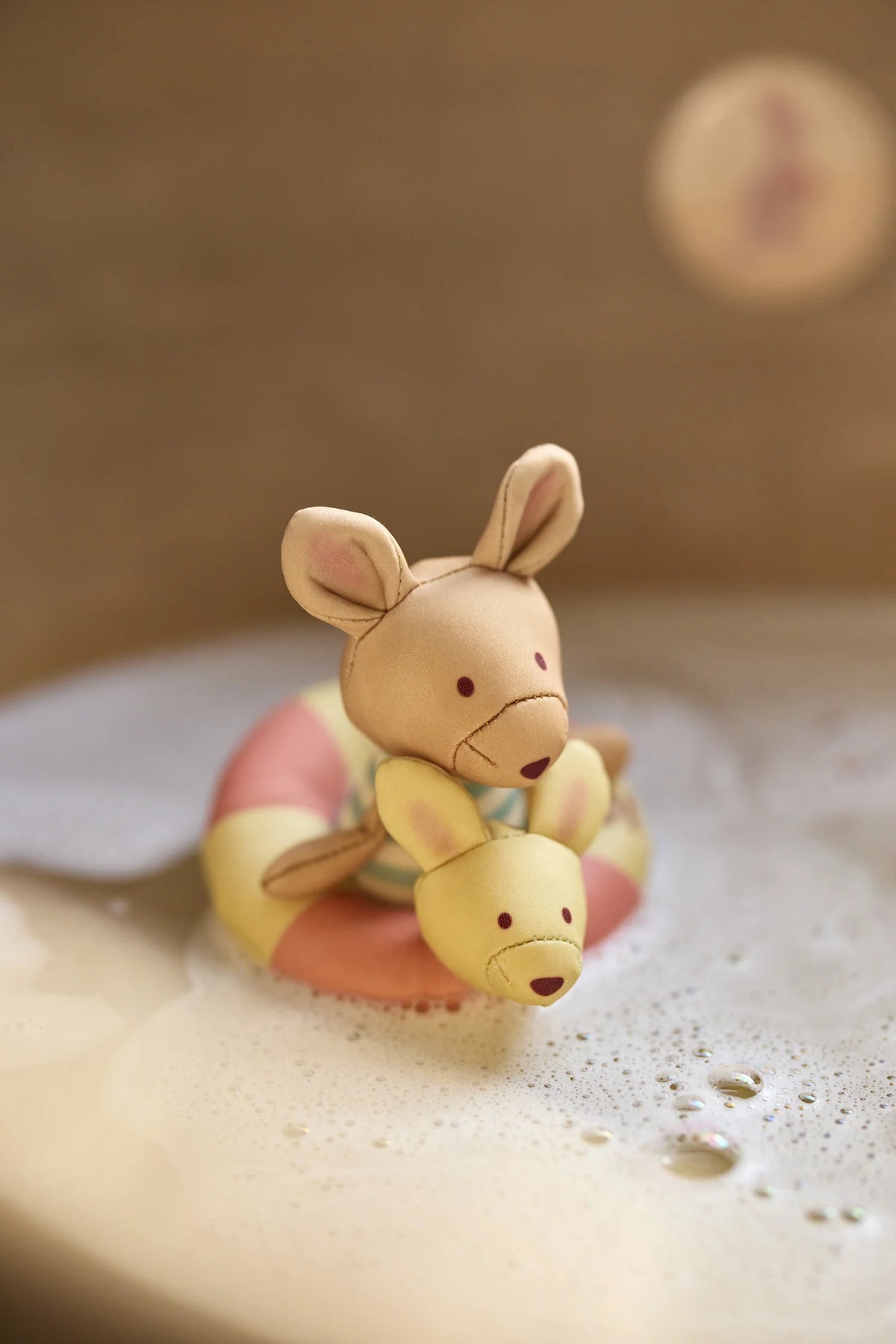 Rendez le bain amusant avec la poupée de bain flottante Kangourou. Étanche, douce et adaptée aux petites mains, elle stimule la motricité fine et l’éveil sensoriel dès 9 mois.