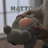 Veilleuse peluche bébé avec projection d’étoiles et sons apaisants. Lumière douce, timer 20 min, parfait pour endormir bébé en toute sécurité.